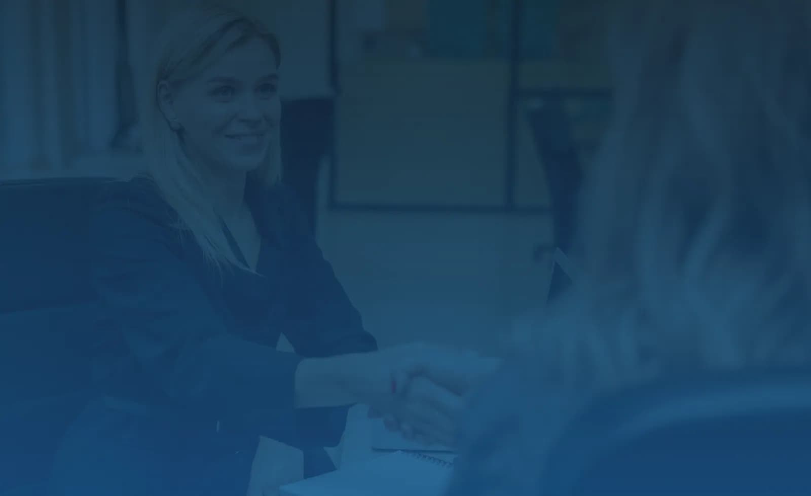Businesswomen shaking hands in a modern office setting