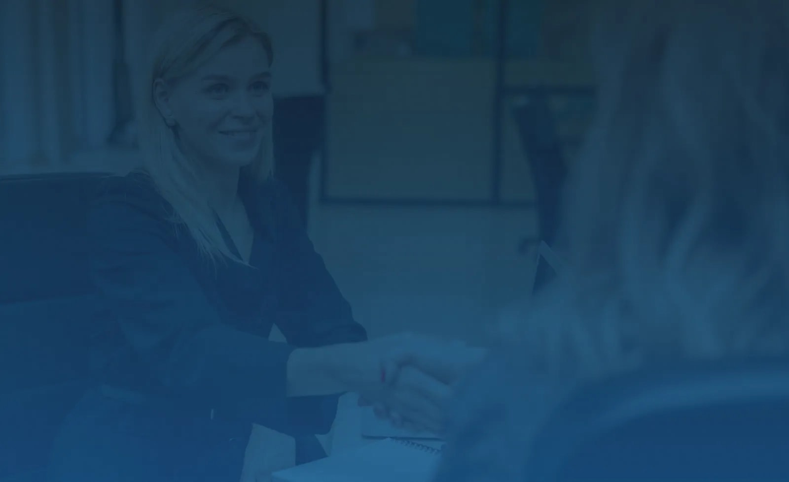 Businesswomen shaking hands in a modern office setting