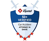 Injured Car Accident Attorney badge, featuring a blue shield with crossed swords, a red plus sign, and the text "Injured," "50+ Verified," "Car Accident Attorney in Davie," and five stars.