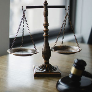 Scales of justice and a gavel resting on a wooden table, symbolizing the principles of law and justice.