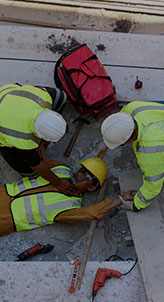 Construction workers attending to an injured coworker on a construction site - Charles Injury Law