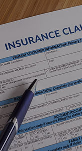 An insurance claim form displayed on a desk, ready for completion, with a pen placed beside it