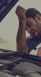 A man inspects the engine of a car, focused on understanding its components and functionality.